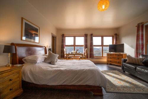 洛欣弗Kirkaig Lodge的一间卧室配有一张大床和一张沙发
