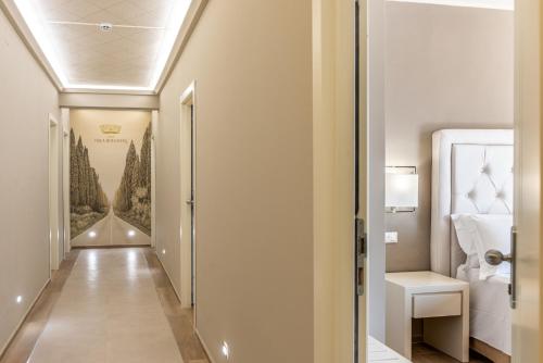 马里纳-迪卡斯塔涅托Hotel Villa Bolgheri的走廊通往带床的房间