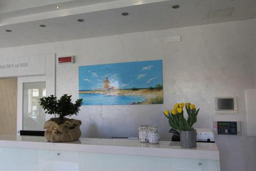 切萨雷奥港Hotel Presidente的厨房柜台墙上有绘画作品