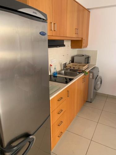 拉纳卡VIP Resort Apartment on Makenzie Beach的厨房配有不锈钢冰箱和水槽