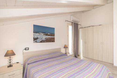 罗萨岛Ulivi 17的白色的卧室设有床和窗户