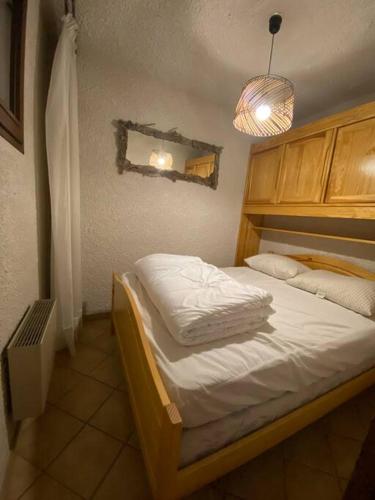 LayeLaye station -les Arolles b - 4 personnes的一间卧室配有一张带白色床单和光线的床