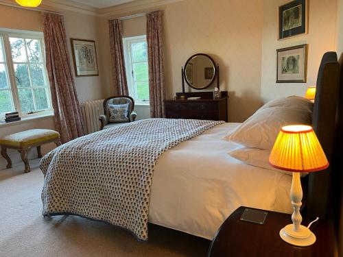 伍勒Yearle House的一间卧室配有一张带灯和镜子的床