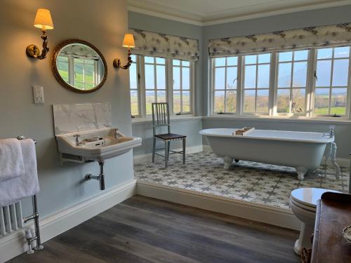 伍勒Yearle House的带浴缸、水槽和镜子的浴室