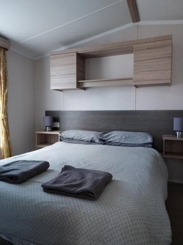 利明顿Shorefield Country Park Self-Catering Holiday Home的卧室配有2个枕头,位于床上