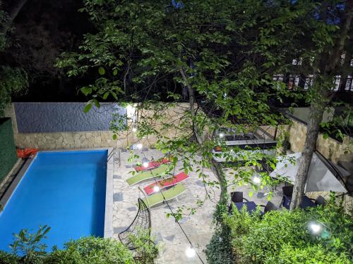 第比利斯萨尼酒店的享有带椅子和树木的游泳池的顶部景致