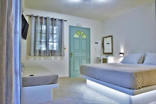 ZefiríaAvra Milos的一间卧室设有两张床和一扇蓝色的门