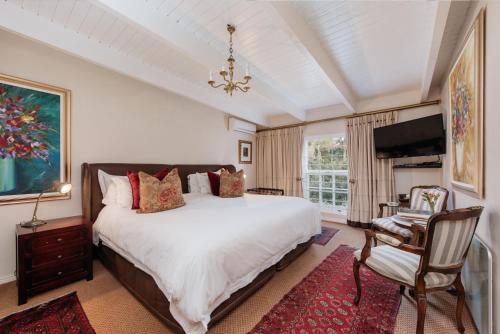 弗朗斯胡克Maison Chablis Guest House的一间带大床和电视的卧室
