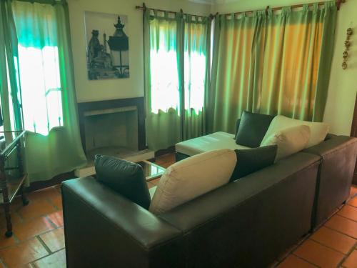 萨尔塔Casa en B° Tres Cerritos, Salta Capital. Alquiler Temporal的客厅设有真皮沙发和窗户。