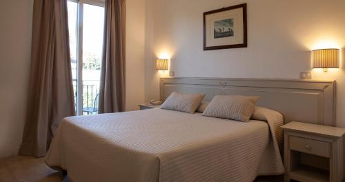 特拉西梅诺湖畔帕西尼亚诺莫提格拖公园公寓的卧室配有白色的床和2个枕头