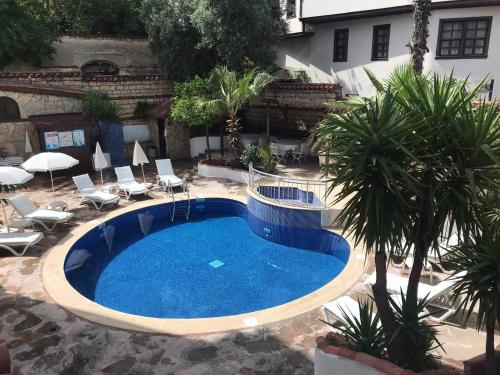 安塔利亚Villa Citronella Boutique Hotel的庭院里的大型游泳池,配有椅子