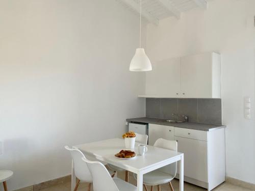 波多河丽Palm Suite Yellow的白色的厨房配有白色的桌子和椅子