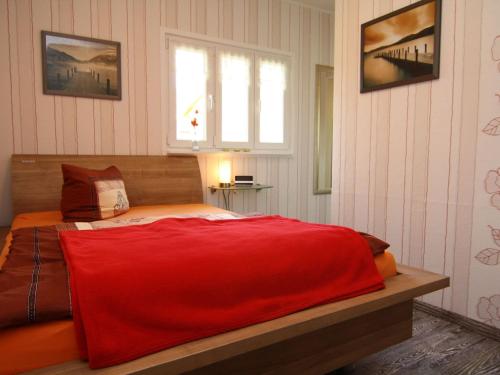 柏林holiday home, Berlin的一间卧室配有一张带红色毯子的床