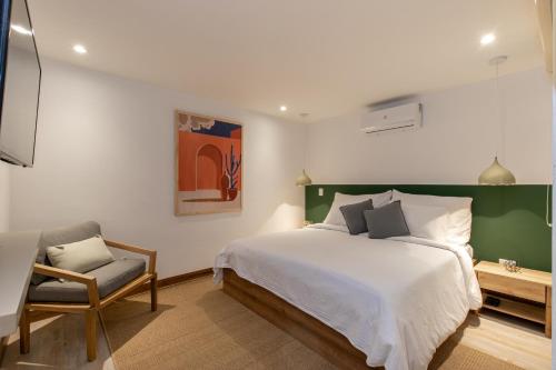 麦德林Villaz Luxury Vacation Homes的一间卧室配有一张大床和一把椅子
