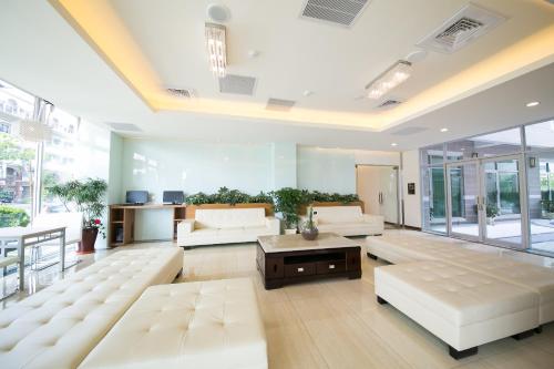 嘉义市夏禾国际行馆 的大型客厅设有白色家具和大窗户