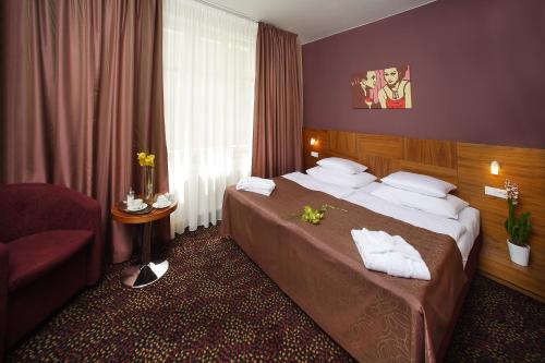 布拉格1共和国酒店的配有一张床和一把椅子的酒店客房