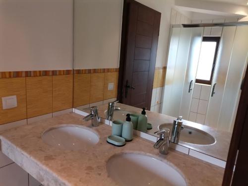 巴尔奇克Black Sea Rama Golf and Villas, Bell Tower Villa的一间带两个盥洗盆和大镜子的浴室