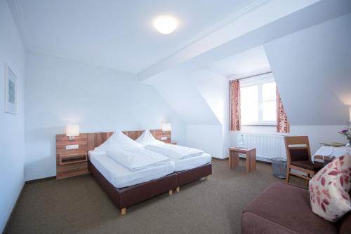 SeinsheimWeingut Kernwein的一间卧室配有一张床、一把椅子和一张沙发