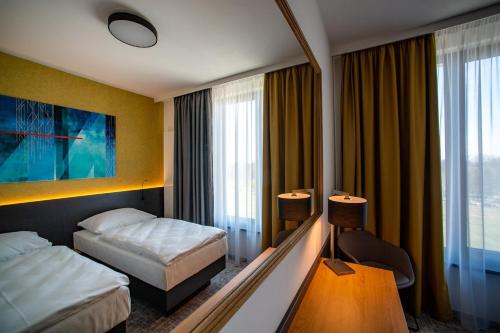 赫拉德茨 - 克拉洛韦EA Congress Hotel Aldis的酒店客房设有两张床和大窗户。