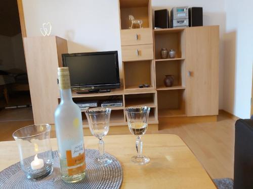 HohenauHaus "Panorama"的桌子上放有一瓶葡萄酒和两杯酒
