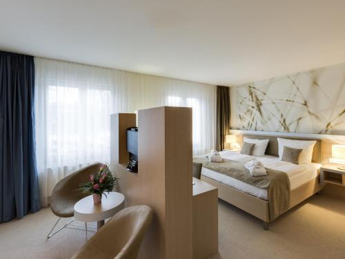 汉诺威汉诺威阿斯普利亚公寓的酒店客房带一张大床和一把椅子
