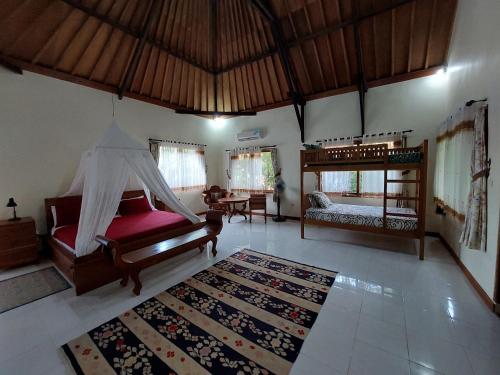 佩母德兰巴厘岛佩母得兰芙蓉住宿加早餐旅馆的一间带床的客厅和一间带地毯的卧室