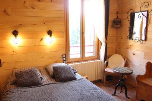 Anlhiac幸福之家酒店的卧室配有木墙内的一张床