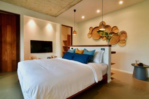 曼谷Coconut Lane Bangkok的卧室配有带蓝色枕头的大型白色床