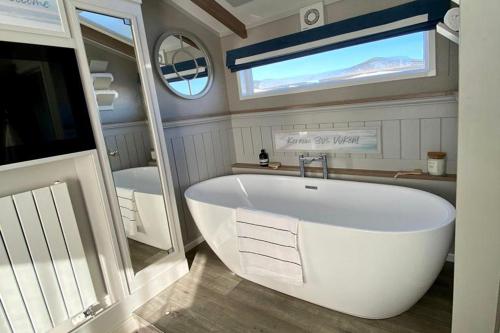 PhillackSt Ives Bay的带窗户的浴室内的白色大浴缸