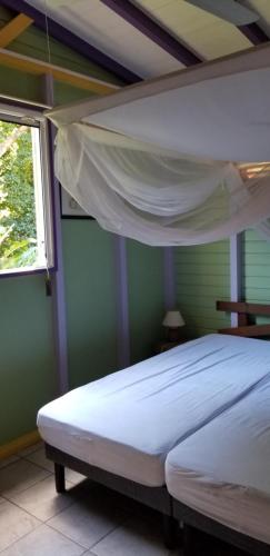 波尔兰特Gites Cabazat的一间设有白色床的卧室,位于一个窗户的房间