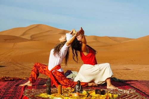 扎古拉berber sahara的两个女人坐在沙漠的毯子上