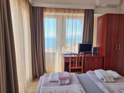 奥赫里德马斯卡斯特罗别墅酒店的酒店客房设有两张床、一张书桌和一个窗户。