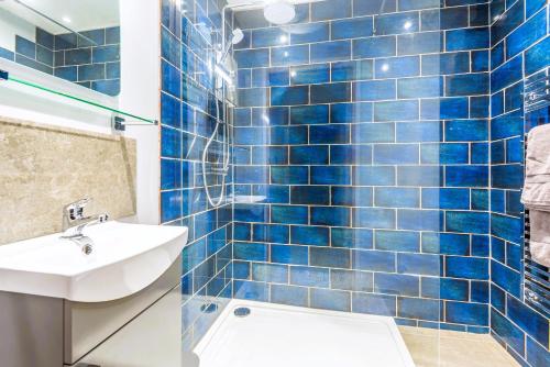 布德Rockpool - Bude的蓝色瓷砖浴室设有水槽和卫生间