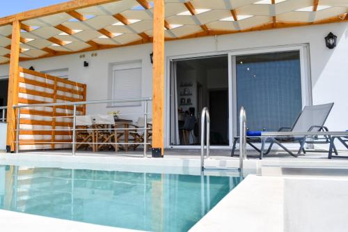 圣加利尼Vrachos Luxury Home 2的一座带游泳池和庭院的房子