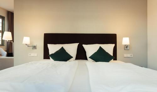 WanfriedZum Schwan Wanfried的卧室配有带绿色枕头的白色床