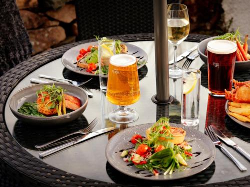 巴特米尔Buttermere Court Hotel的餐桌,带食物盘和啤酒杯