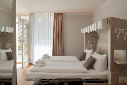 巴贝R&R Hotel Strandallee的一间卧室设有两张床和大窗户