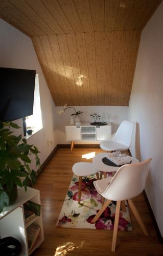 ThumGästezimmer im Grünen Haus的客厅配有两把椅子、一张桌子和一台电视
