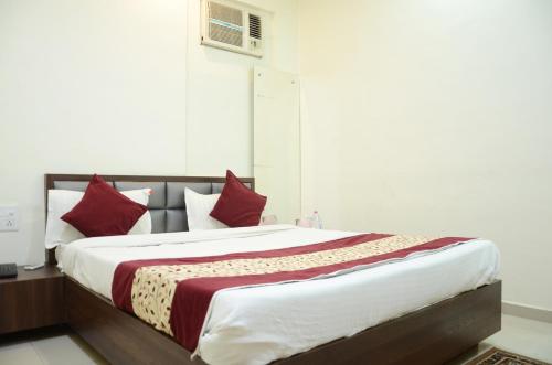 占西Hotel hari palace的一间卧室配有一张带红色枕头的大床