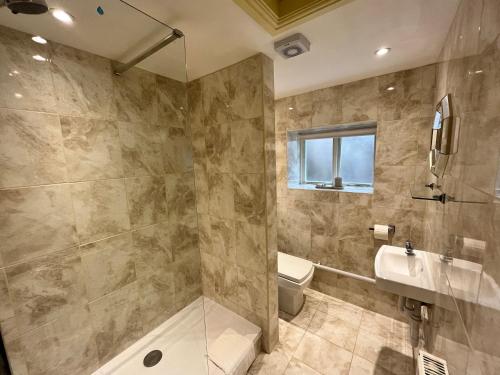 利德尼Swan House Tea Room and Bed & Breakfast的带淋浴、卫生间和盥洗盆的浴室