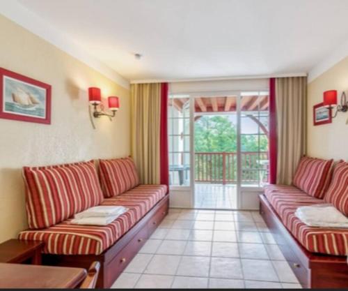 比斯卡罗斯Biscarrosse Lac-Domaine de Gascogne- avec piscine的一间带两张沙发的客厅和一个阳台