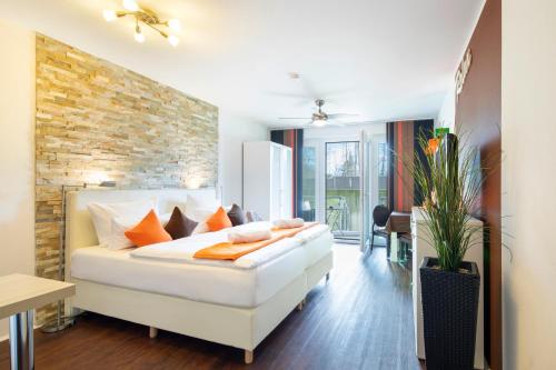 科隆胡瑟科隆美尼公寓式酒店的卧室配有白色的床和砖墙
