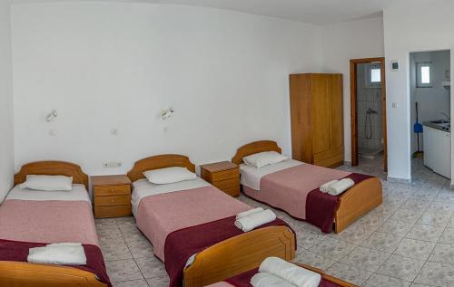 利迈纳里亚Villa Chrissa的酒店客房设有三张床和一间浴室。