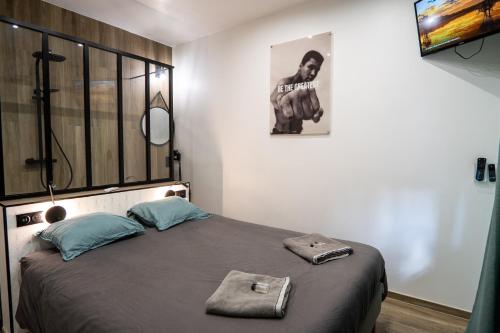 瓦朗西纳Capsule Wellness - sauna - balneo - machine de sport privatif - PS5 - 2 chambres的一间卧室设有一张大床和大窗户