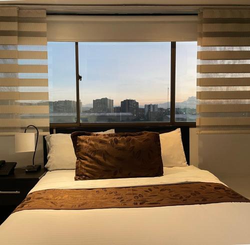 波哥大Hotel Airport Travel的一间卧室设有一张大床和大窗户