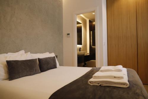 科尔多瓦MEDINA HOMES PUENTE ROMANO的一间卧室配有一张床,床上有毛巾