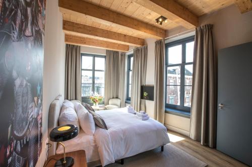 NieuwersluisBistrotel 't Amsterdammertje的卧室设有白色大床和窗户。