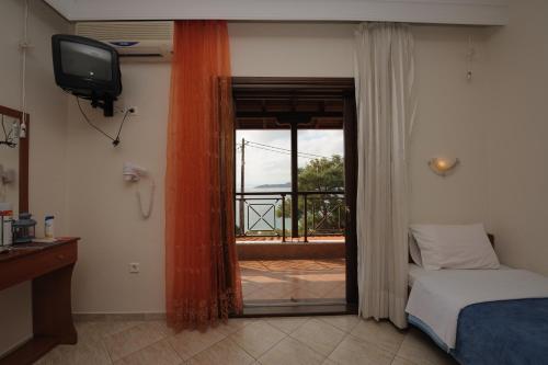 欧拉努波利斯Panorama Spa Hotel的一间卧室配有一张床、一台电视和一个阳台