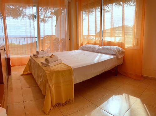 滨海托萨APPARTEMENTS SOL y MAR - Cala Llevado 2的一间卧室配有一张带桌子和窗户的床。