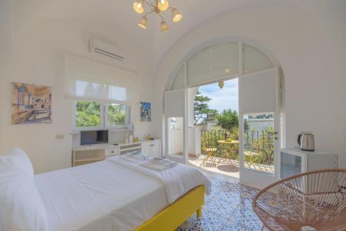 卡普里Villa Dorothee的一间白色卧室,配有床和阳台